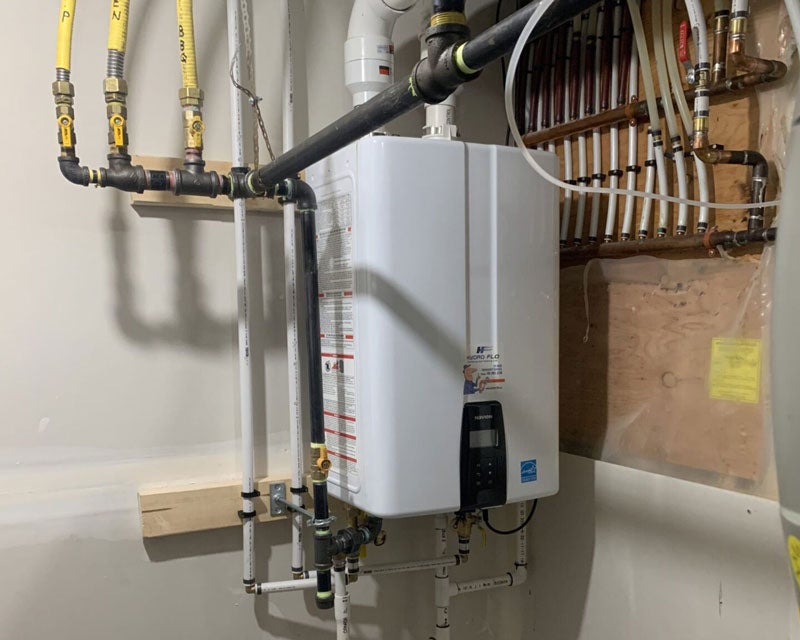 A white tankless water heater installed by Hydro-Flo Plumbing & Heating in Edmonton, AB