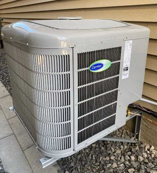A Carrier AC unit mounted on the side of a house in Edmonton, AB
